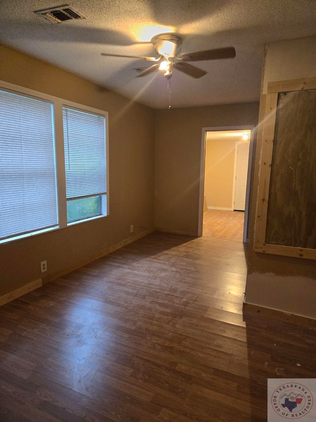 spare room featuring ceiling fan, wood-type flooring, and a textured ceiling