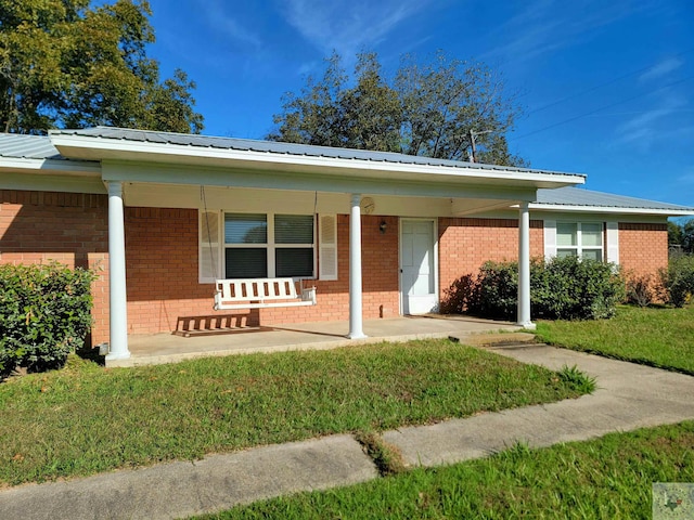 single story home with covered porch and a front yard