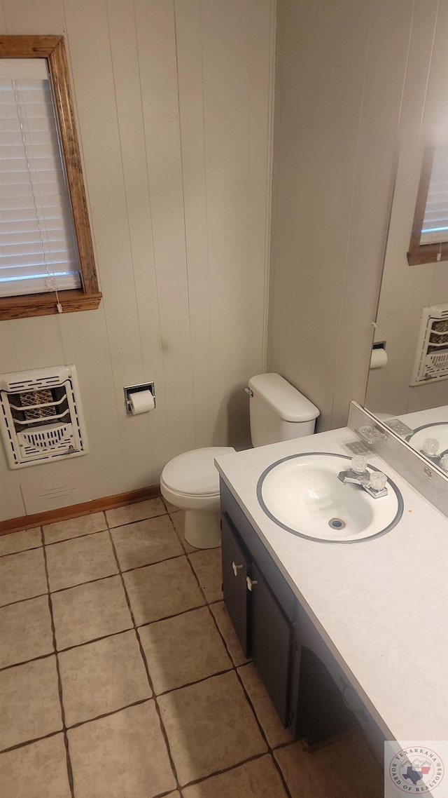 bathroom featuring vanity, heating unit, tile patterned floors, and toilet