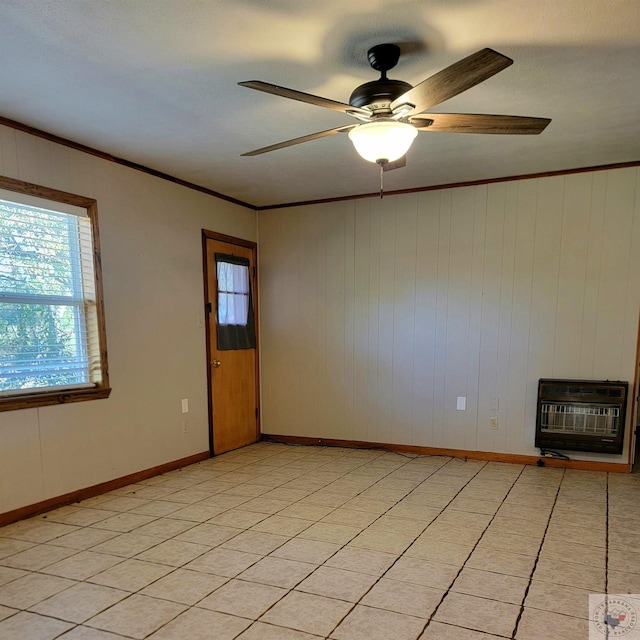 tiled empty room featuring wood walls, heating unit, ceiling fan, and ornamental molding