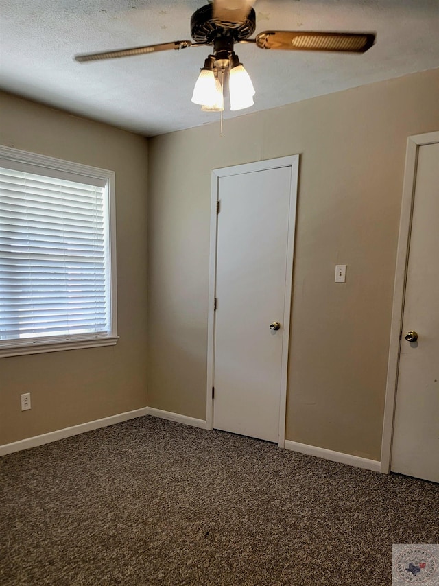 unfurnished room featuring ceiling fan and carpet