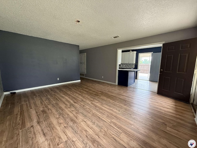 909 Pacific Ave, Wake Village, TX 75501 - spare room featuring a textured ceiling, wood finished floors, and baseboards