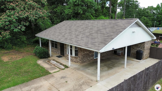 909 Pacific Ave, Wake Village, TX 75501 - view of front of house featuring concrete driveway, a shingled roof, brick siding, and a carport
