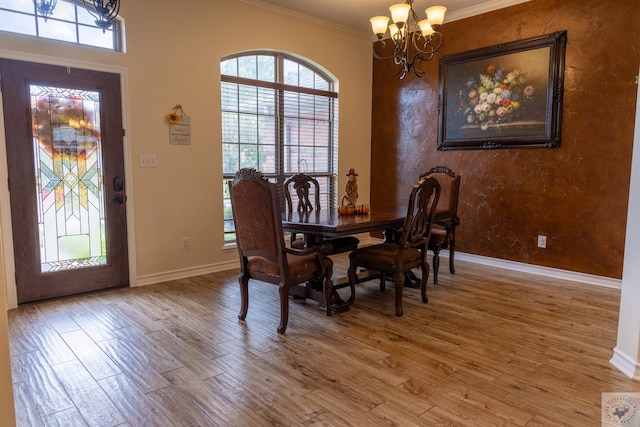 dining space featuring a notable chandelier, ornamental molding, and hardwood / wood-style floors