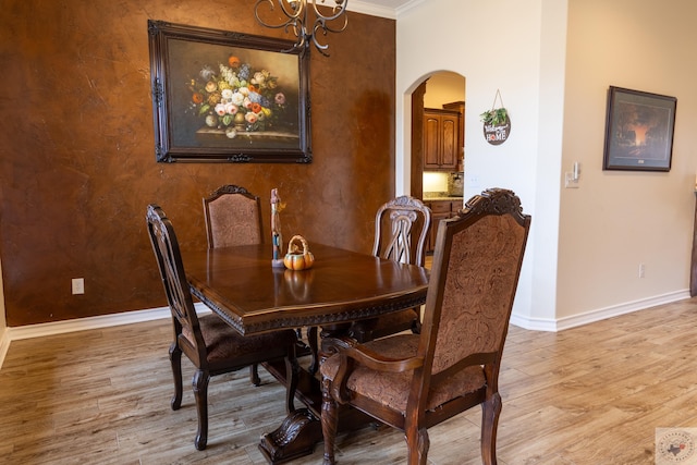 dining area featuring light wood-type flooring and ornamental molding