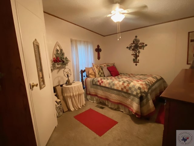 carpeted bedroom featuring ceiling fan, crown molding, and a textured ceiling