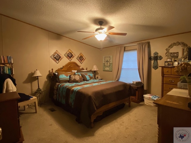 carpeted bedroom with ceiling fan, a textured ceiling, and ornamental molding