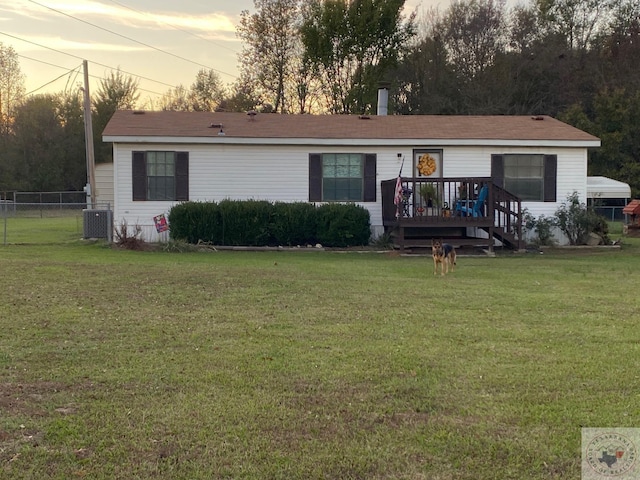 view of front of property with a deck, cooling unit, and a lawn