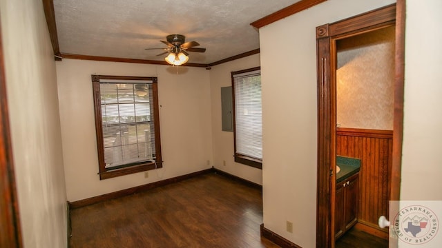 empty room featuring a textured ceiling, dark hardwood / wood-style flooring, and crown molding