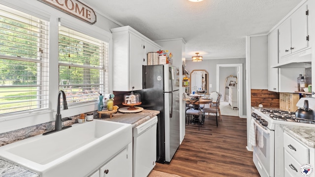 9216 W 7th St, Redwater, TX 75501 - kitchen with white appliances, a textured ceiling, a sink, under cabinet range hood, and dark wood-style floors