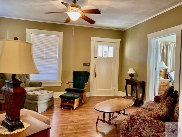 living room featuring crown molding, light hardwood / wood-style floors, and ceiling fan