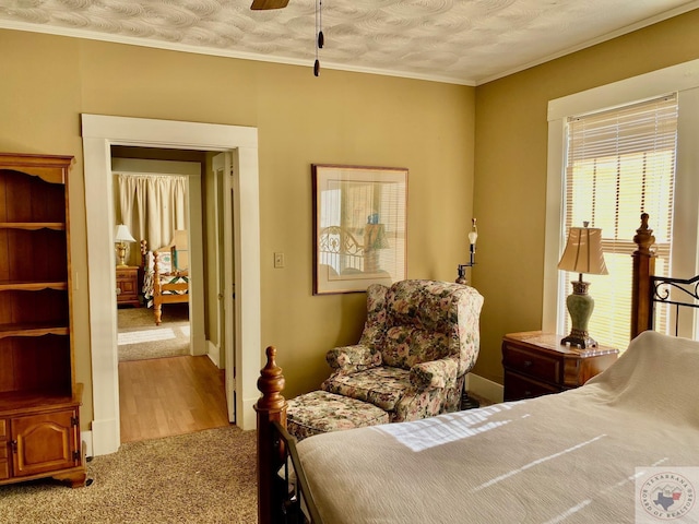 bedroom with ceiling fan, a textured ceiling, ornamental molding, and carpet floors