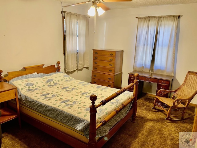 bedroom featuring ceiling fan, a textured ceiling, and dark carpet