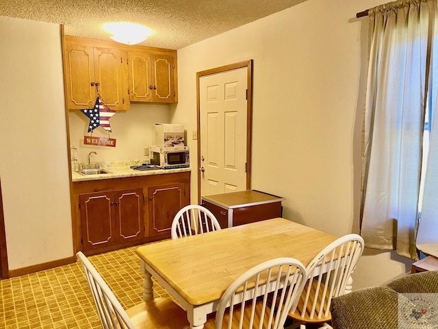 dining space with sink and a textured ceiling