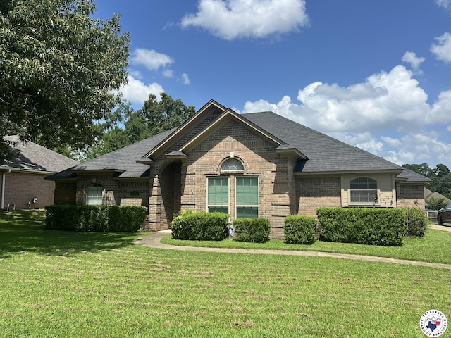 5902 Oak Hollow Pl, Texarkana, AR 71854 - french country home with brick siding, a front lawn, and roof with shingles