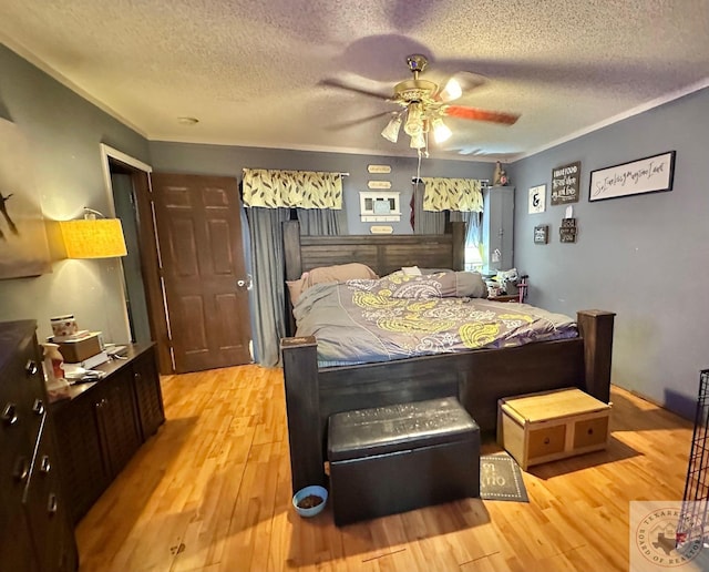 bedroom featuring a textured ceiling, ceiling fan, and light wood finished floors