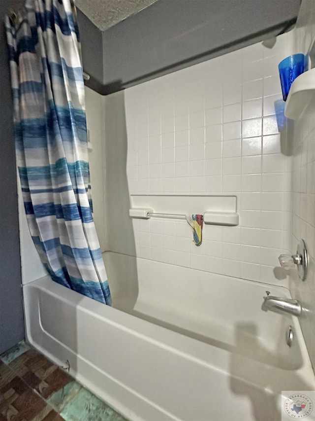 full bathroom featuring a textured ceiling and shower / tub combo with curtain