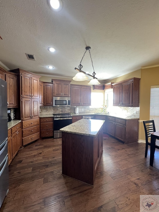 kitchen featuring a center island, crown molding, sink, pendant lighting, and stainless steel appliances