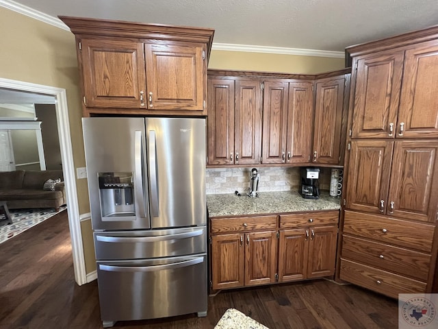 kitchen featuring light stone counters, stainless steel refrigerator with ice dispenser, dark hardwood / wood-style floors, and ornamental molding