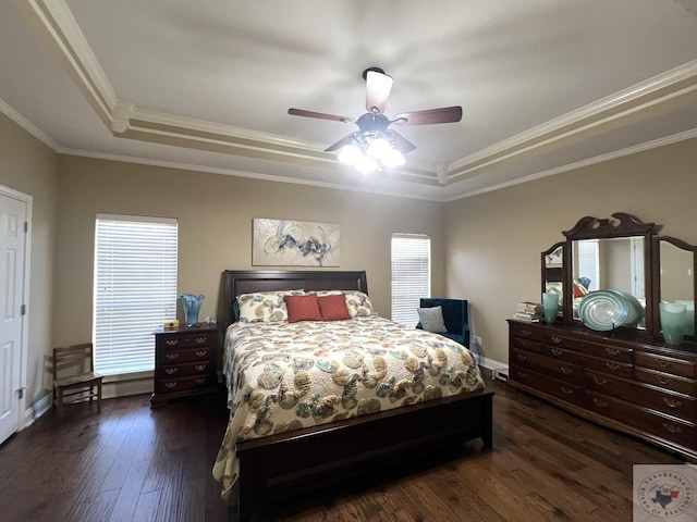 bedroom with ceiling fan, dark hardwood / wood-style flooring, a tray ceiling, and crown molding