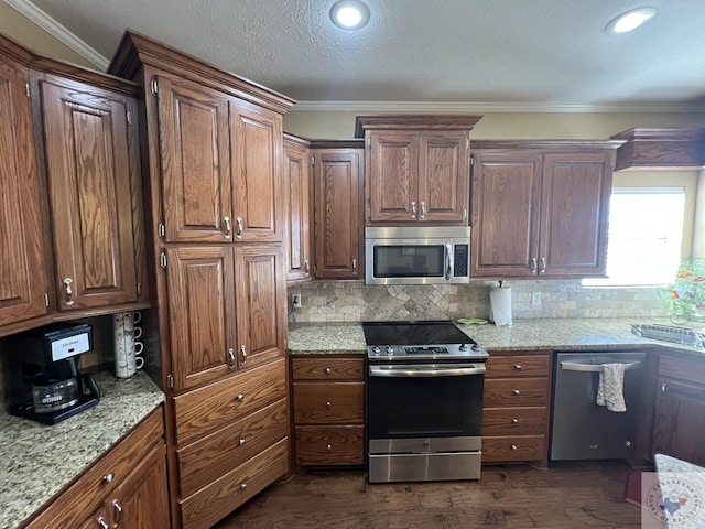 kitchen featuring ornamental molding, backsplash, light stone countertops, and appliances with stainless steel finishes