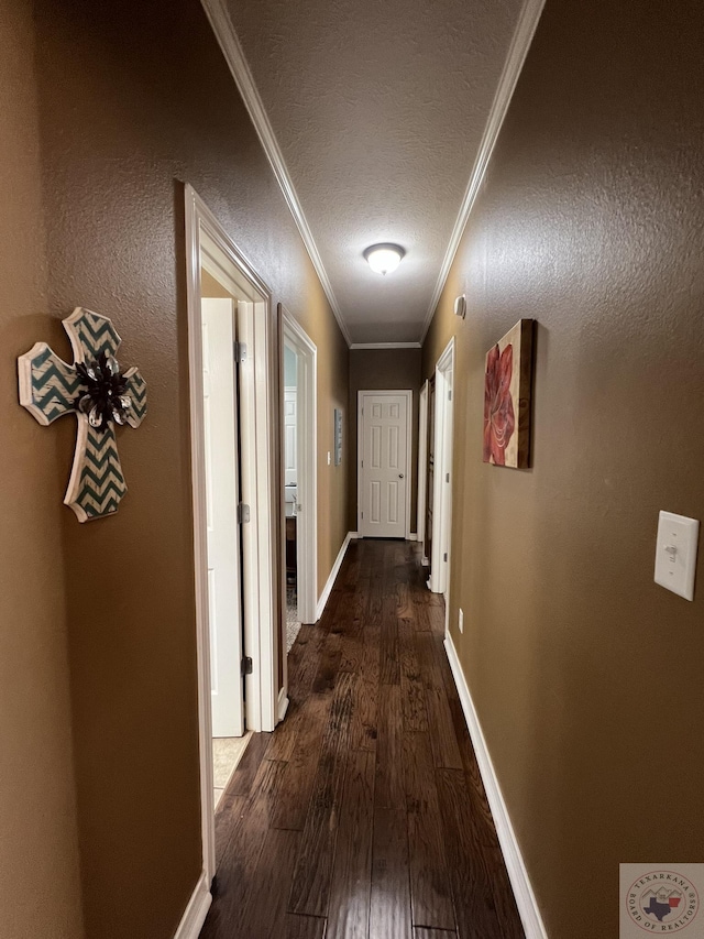 hallway with dark hardwood / wood-style flooring, crown molding, and a textured ceiling