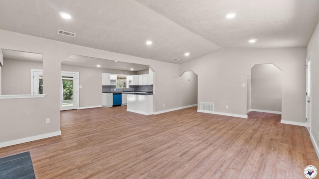 1911 Vanderbilt Rd, Texarkana, AR 71854 - unfurnished living room with light wood-style flooring, arched walkways, recessed lighting, and lofted ceiling