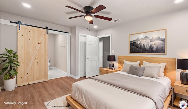 1911 Vanderbilt Rd, Texarkana, AR 71854 - bedroom with a barn door, recessed lighting, wood finished floors, ensuite bathroom, and a ceiling fan