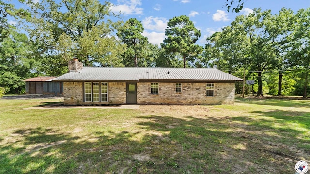 1911 Vanderbilt Rd, Texarkana, AR 71854 - rear view of property featuring a chimney, brick siding, a lawn, and a metal roof