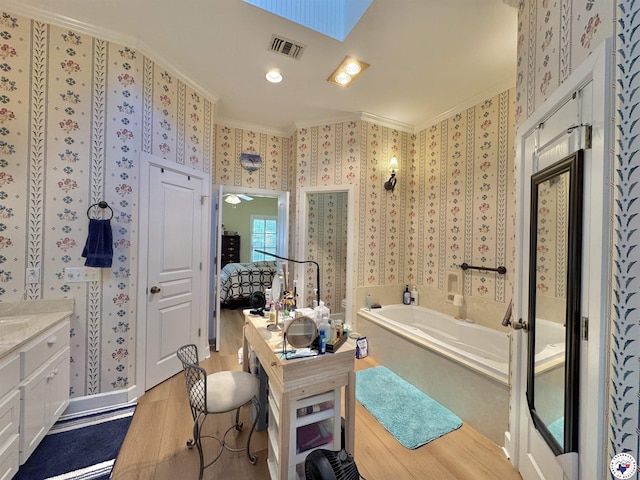 ensuite bathroom featuring ornamental molding, vanity, wood finished floors, and wallpapered walls