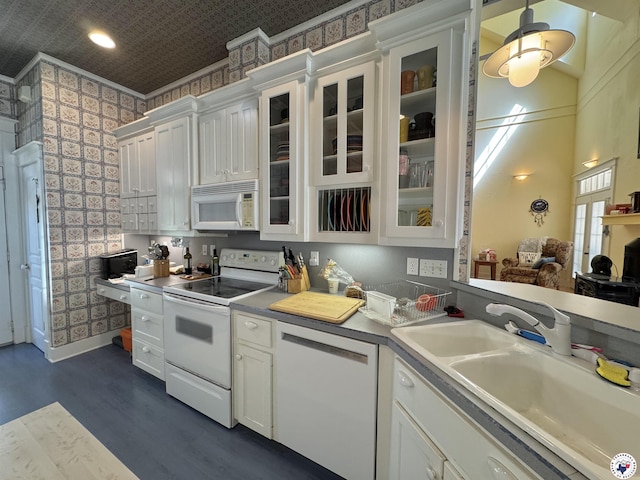 kitchen with dark wood-style floors, white cabinetry, a sink, and white appliances