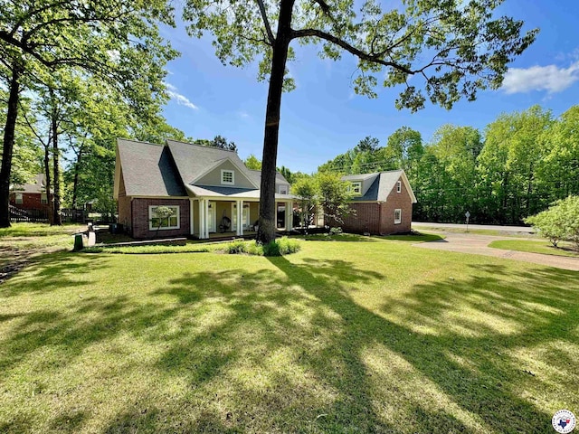 view of front of home featuring a porch, a front yard, and brick siding