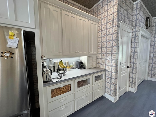 bar with wallpapered walls, dark wood-type flooring, and freestanding refrigerator