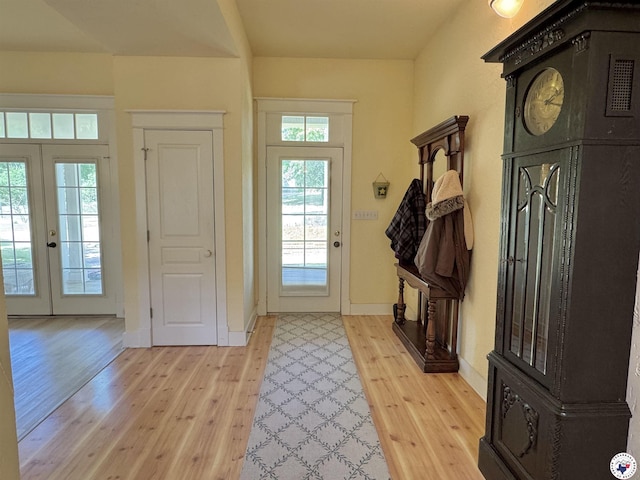 entryway featuring light wood-style floors, french doors, and baseboards
