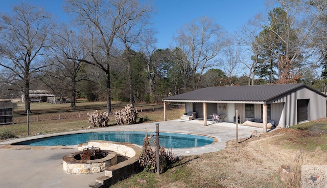 view of swimming pool with a patio area, an outbuilding, and a fire pit