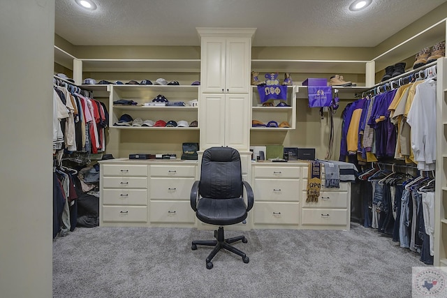 spacious closet featuring light colored carpet