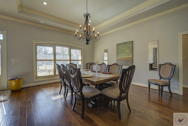 dining room with dark hardwood / wood-style flooring, ornamental molding, a raised ceiling, and a chandelier