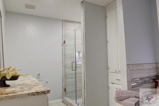 bathroom with visible vents, a shower stall, and baseboards