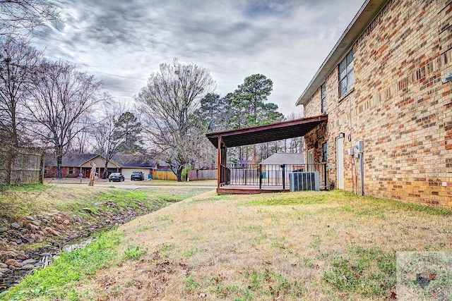 view of yard featuring fence and central AC