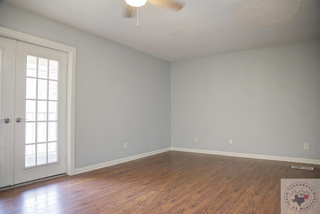 spare room with ceiling fan, wood finished floors, visible vents, and baseboards