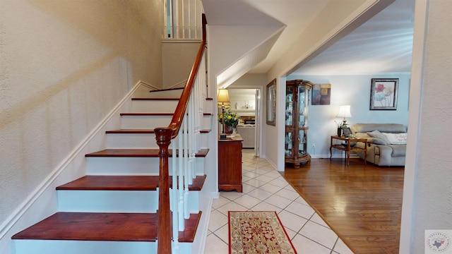 staircase featuring tile patterned flooring and ornate columns