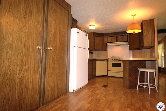 334 Pine Valley Rd, Texarkana, TX 75501 - kitchen featuring white appliances, under cabinet range hood, wood finished floors, a peninsula, and backsplash