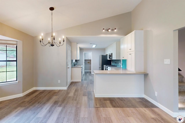 403 Edgewood Ln, Wake Village, TX 75501 - kitchen featuring stainless steel appliances, white cabinets, a chandelier, light wood-style floors, and lofted ceiling