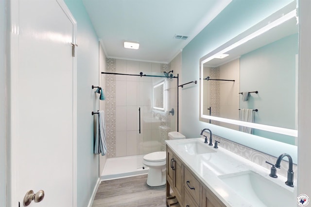 403 Edgewood Ln, Wake Village, TX 75501 - bathroom with toilet, wood finished floors, double vanity, tiled shower, and ornamental molding
