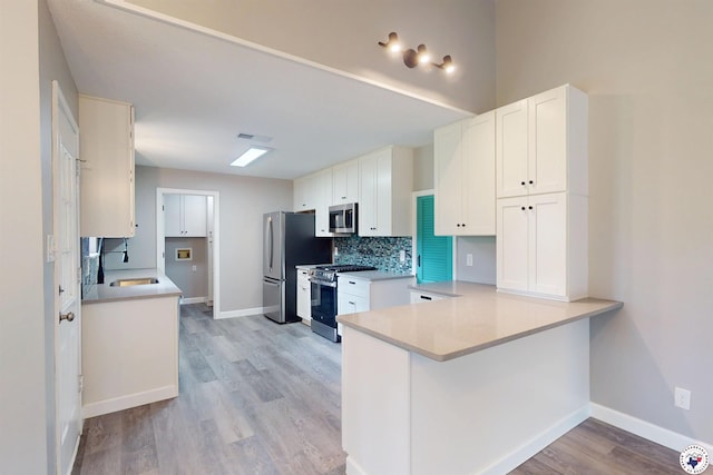 403 Edgewood Ln, Wake Village, TX 75501 - kitchen with appliances with stainless steel finishes, a sink, white cabinets, light wood-style flooring, and light countertops