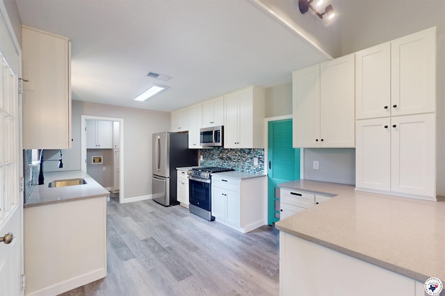 403 Edgewood Ln, Wake Village, TX 75501 - kitchen featuring a sink, stainless steel appliances, light wood-style flooring, tasteful backsplash, and white cabinets