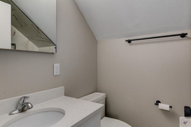 bathroom with vanity, vaulted ceiling, and toilet