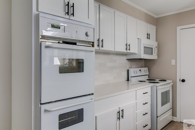 kitchen with white appliances, crown molding, tasteful backsplash, wood-type flooring, and white cabinetry