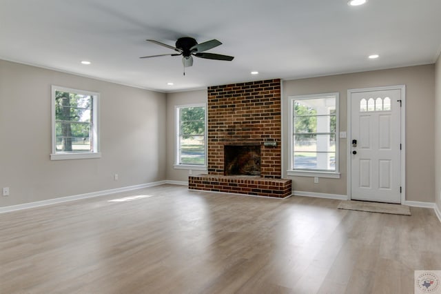 unfurnished living room with ceiling fan, light hardwood / wood-style flooring, plenty of natural light, and a fireplace