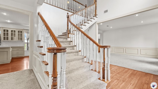 14 Stonewall Trce, Texarkana, TX 75503 - staircase with recessed lighting, wood finished floors, carpet, a wainscoted wall, and a high ceiling